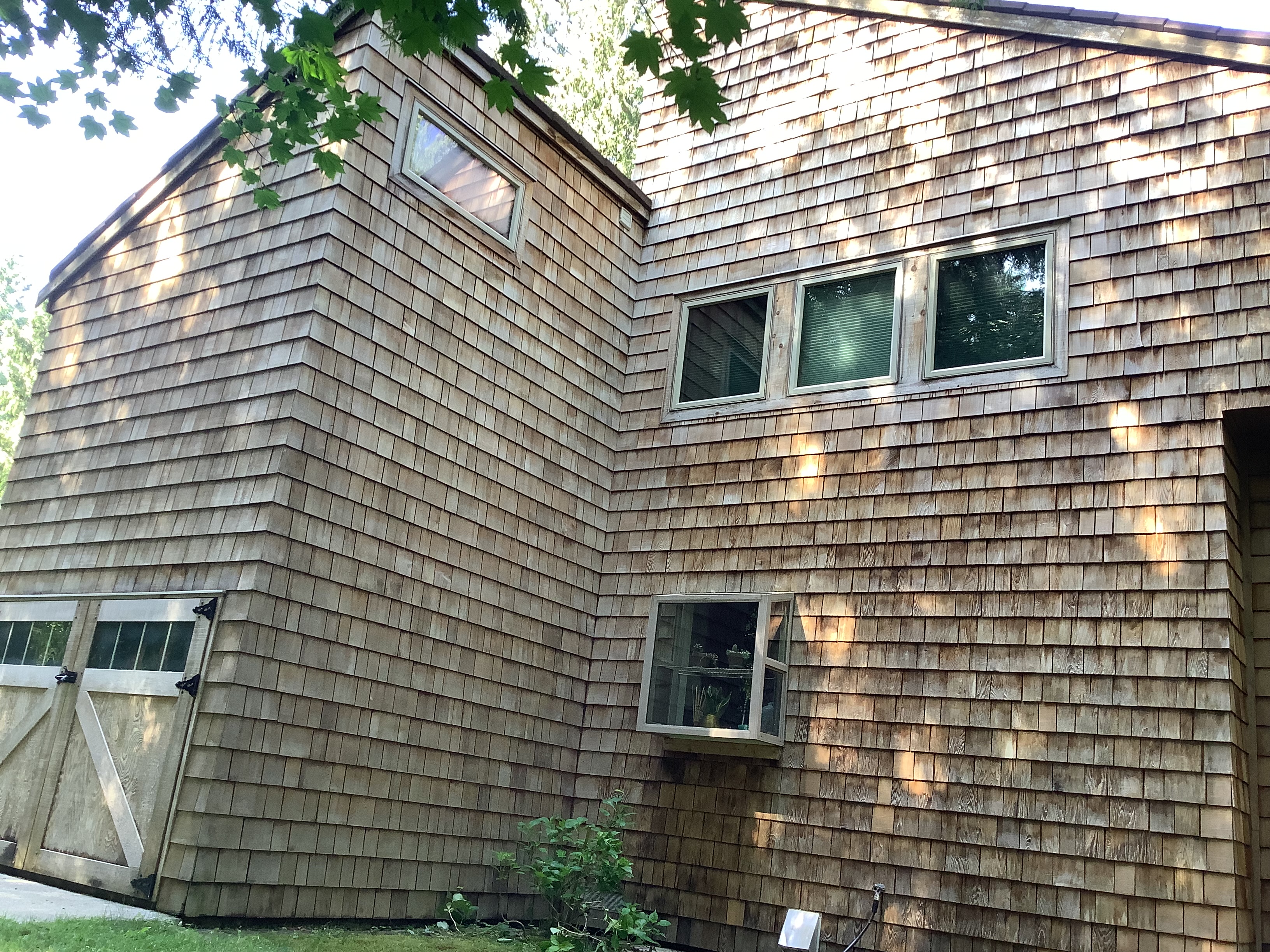 Close view of cedar shake siding and windows before exterior staining