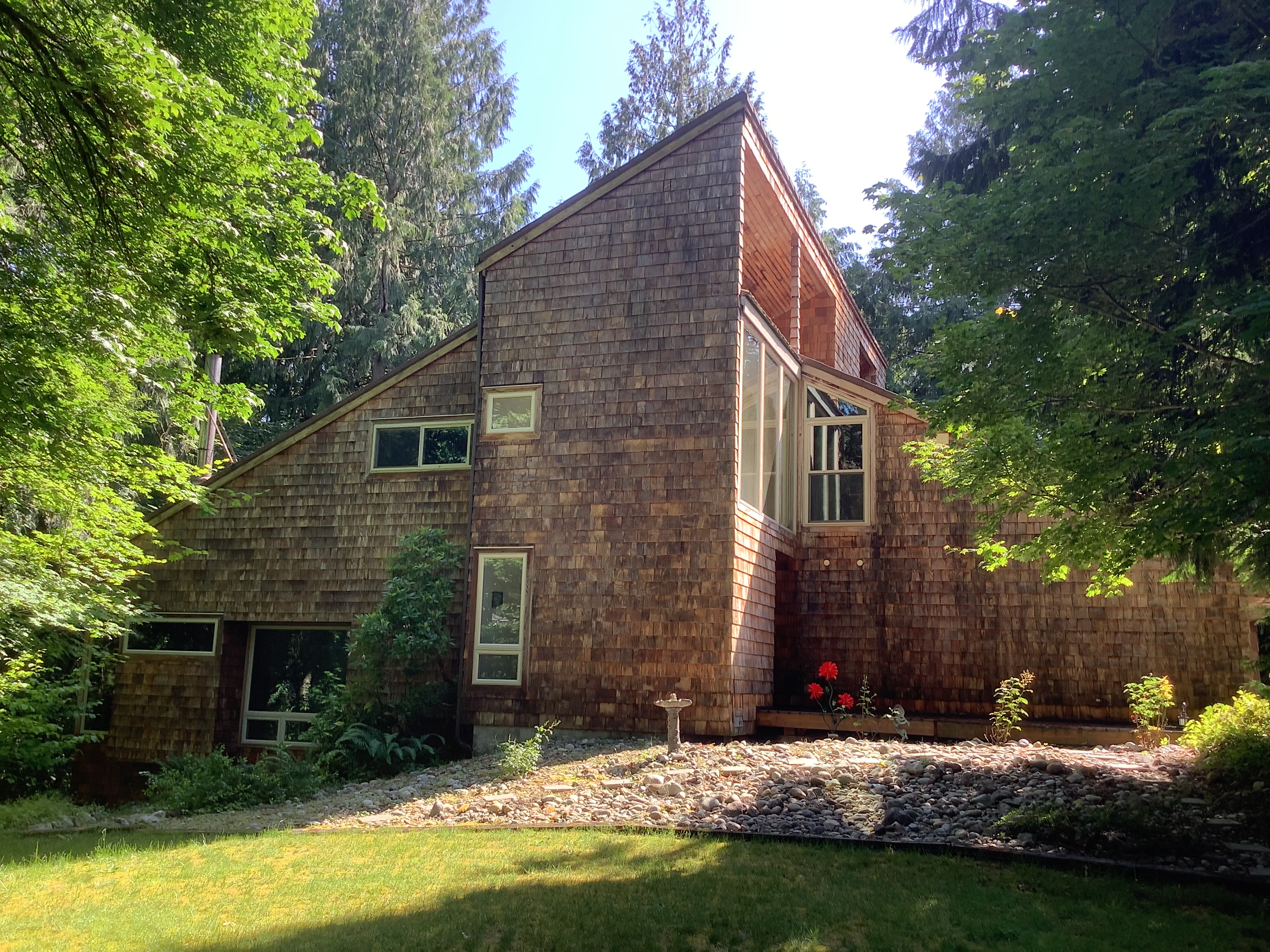 Cedar shake home with tall gable windows before exterior staining