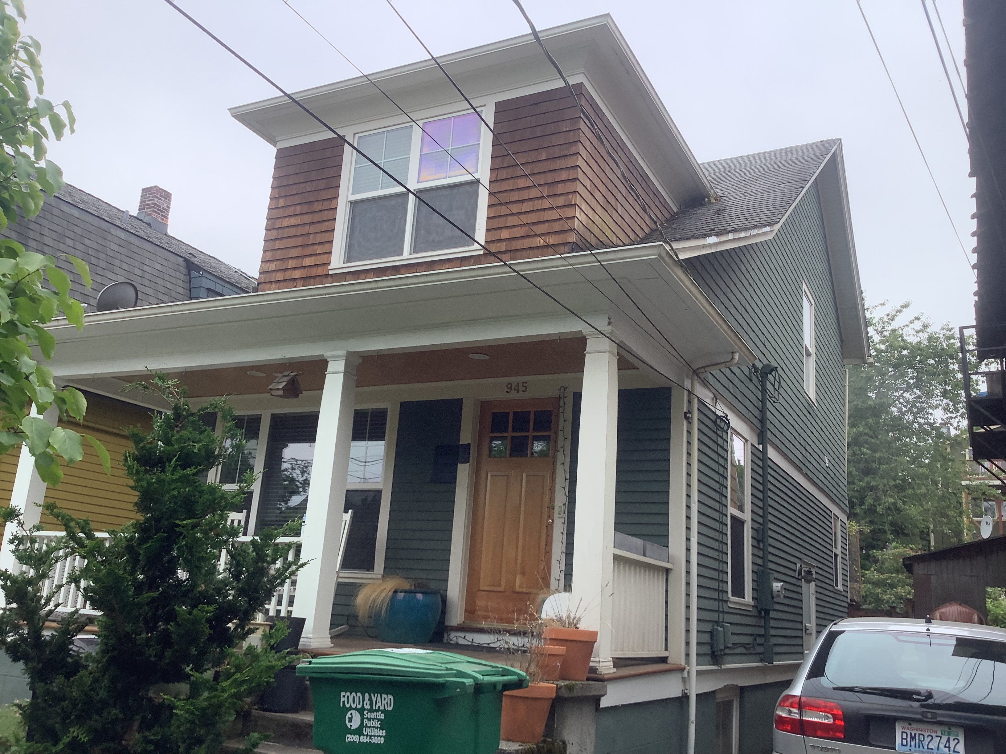Green Seattle bungalow with white porch before exterior painting