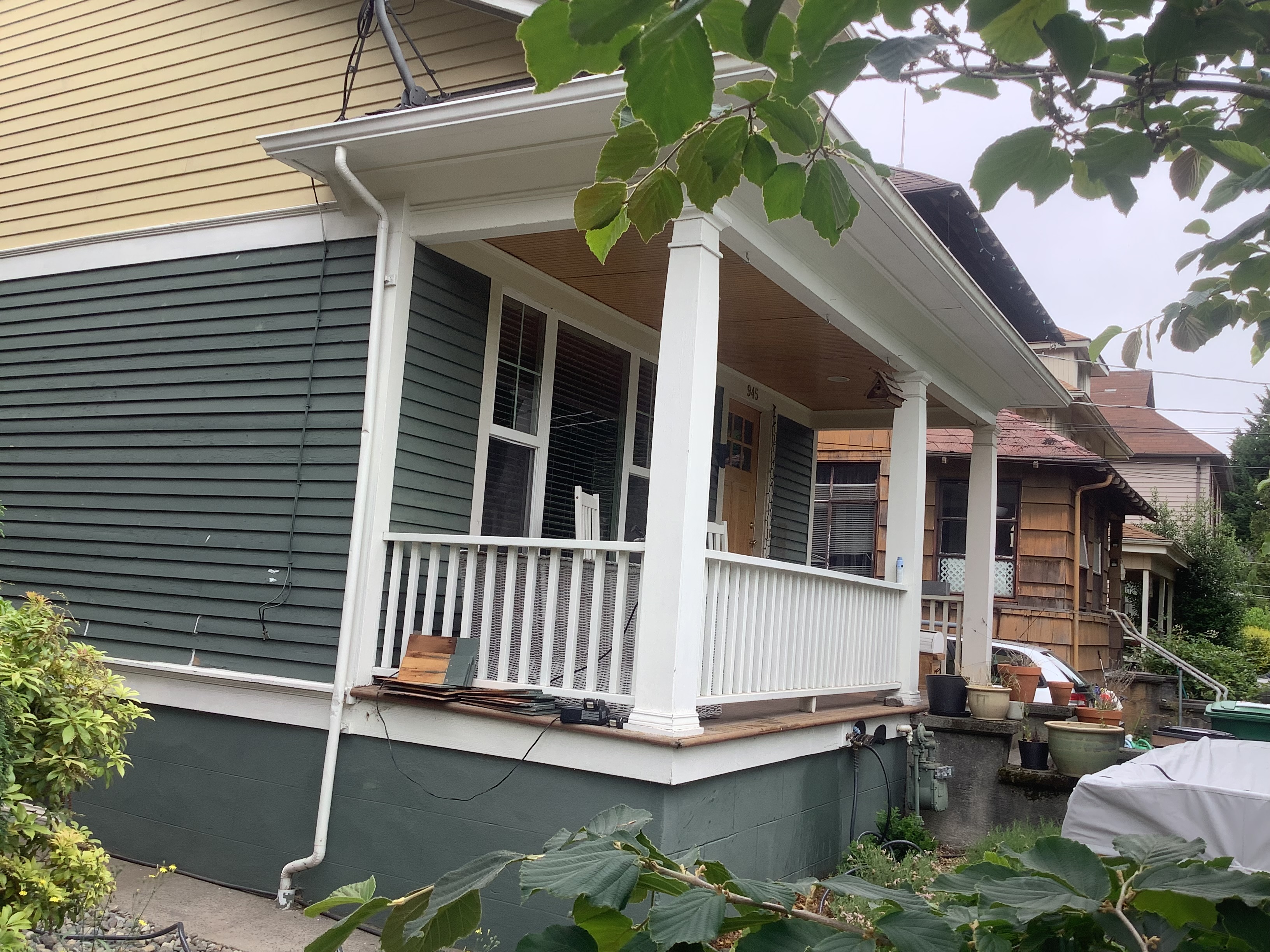 White porch columns and green siding on a Seattle home before painting