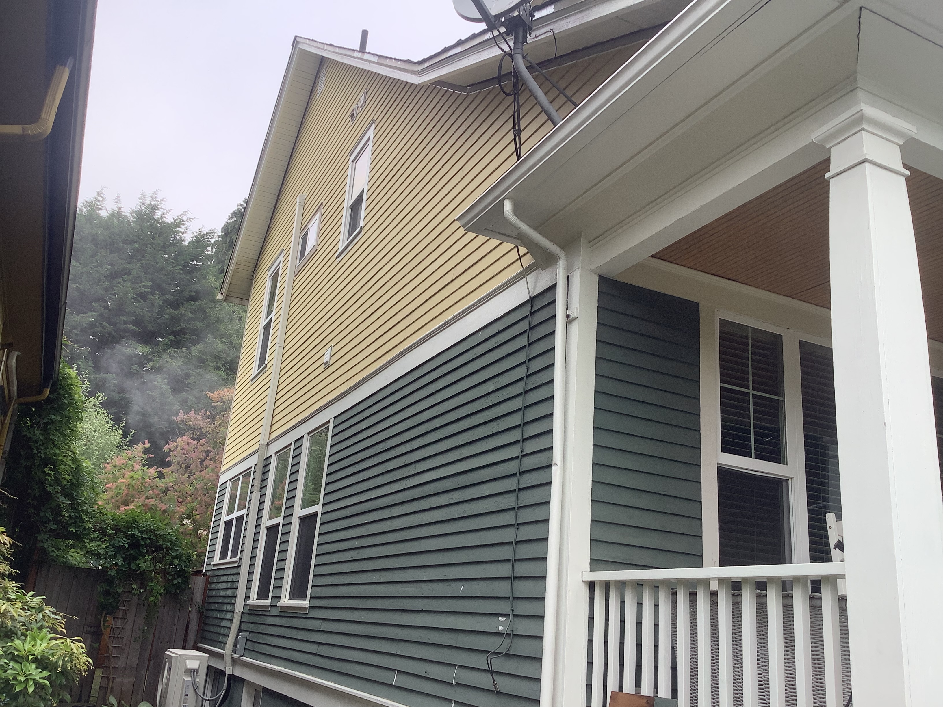 Yellow upper siding and green lower siding before exterior painting