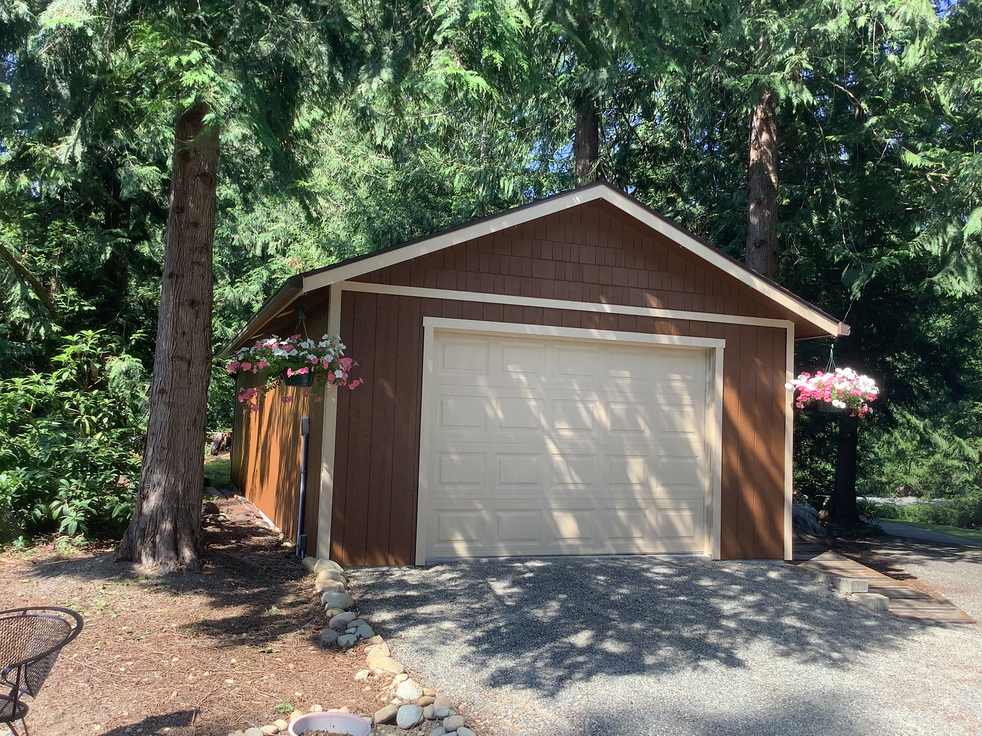 Brown garage exterior with cream trim and hanging flower baskets