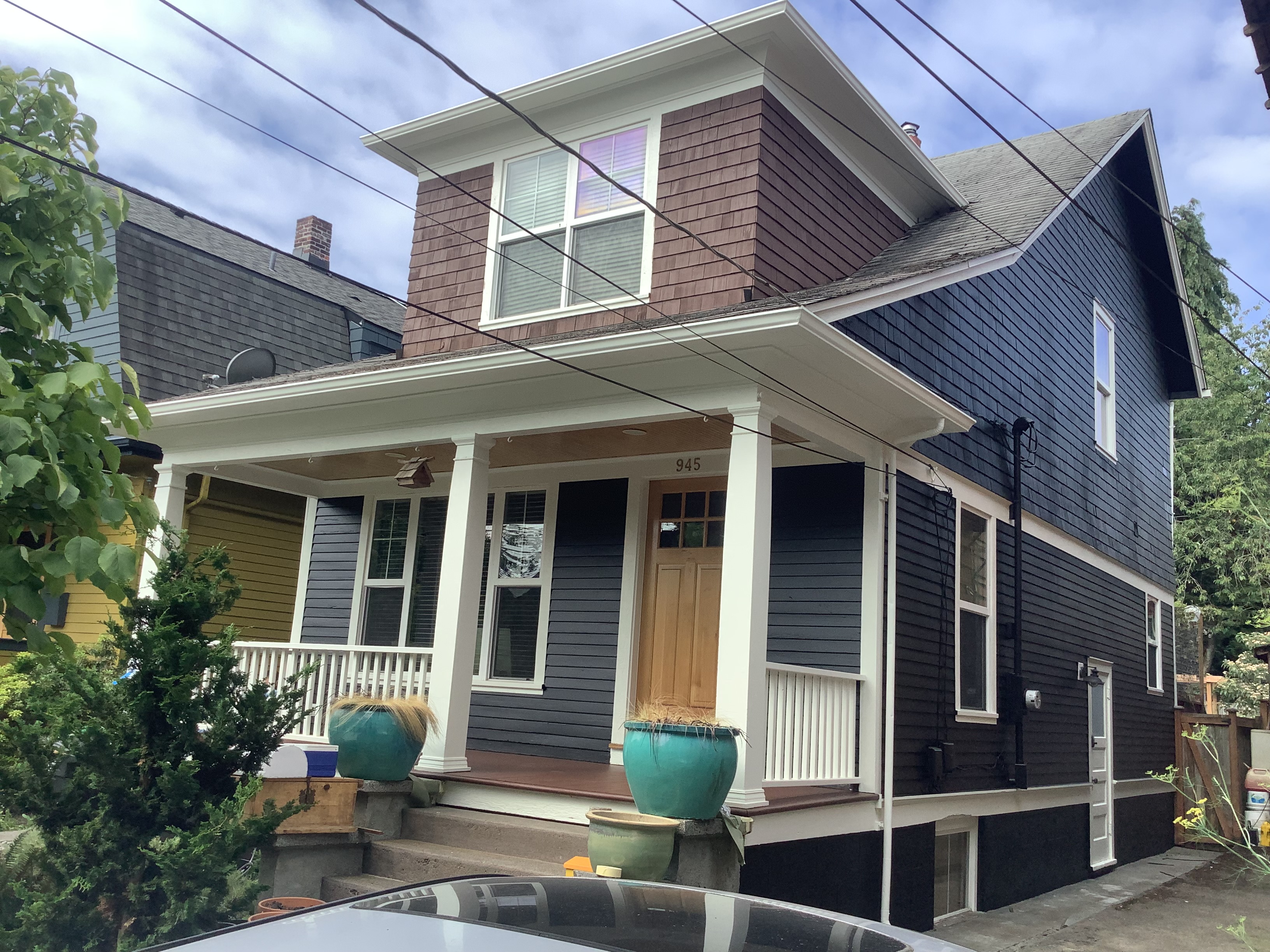 Freshly painted navy Seattle bungalow with white porch columns