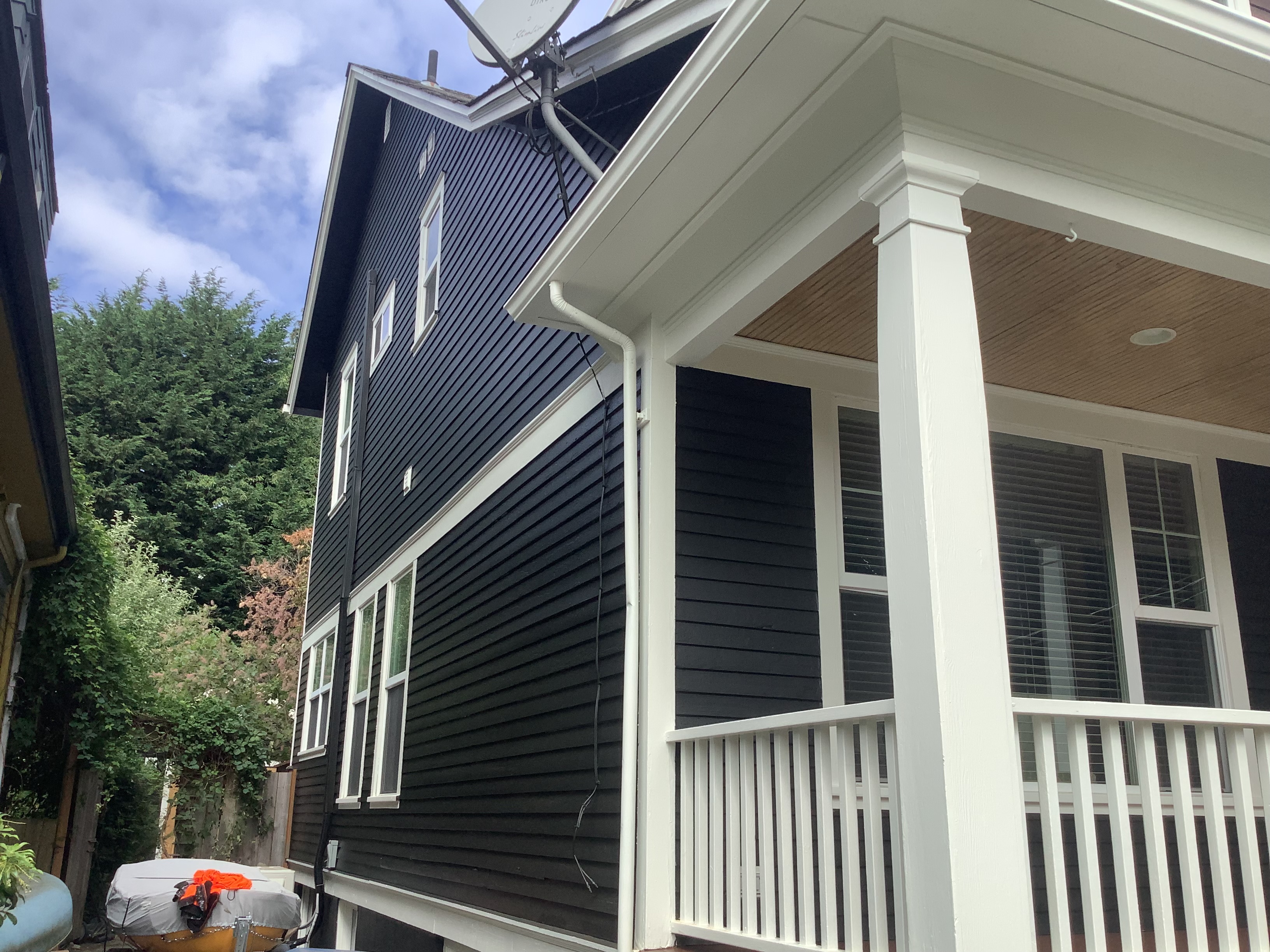 Navy siding and white porch railing after exterior painting